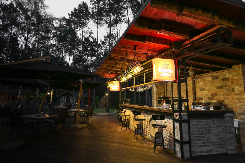 Il bar esterno si apre su un patio ed è circondato da una grande foresta di pini.