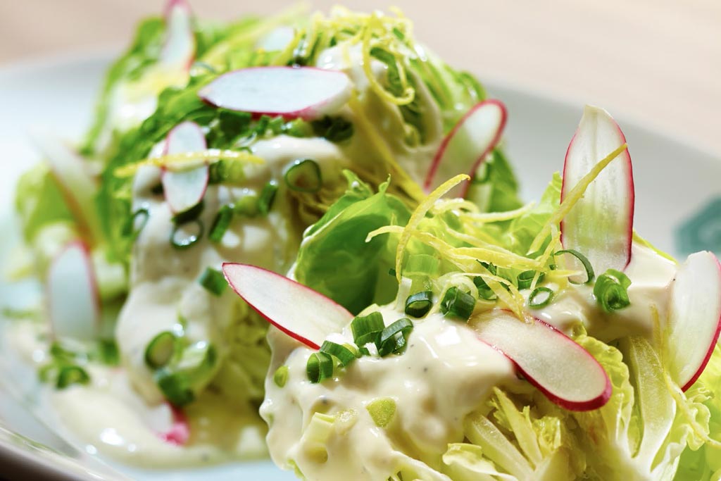 Insalata di lattuga con rapanelli, cipollotto e limone.